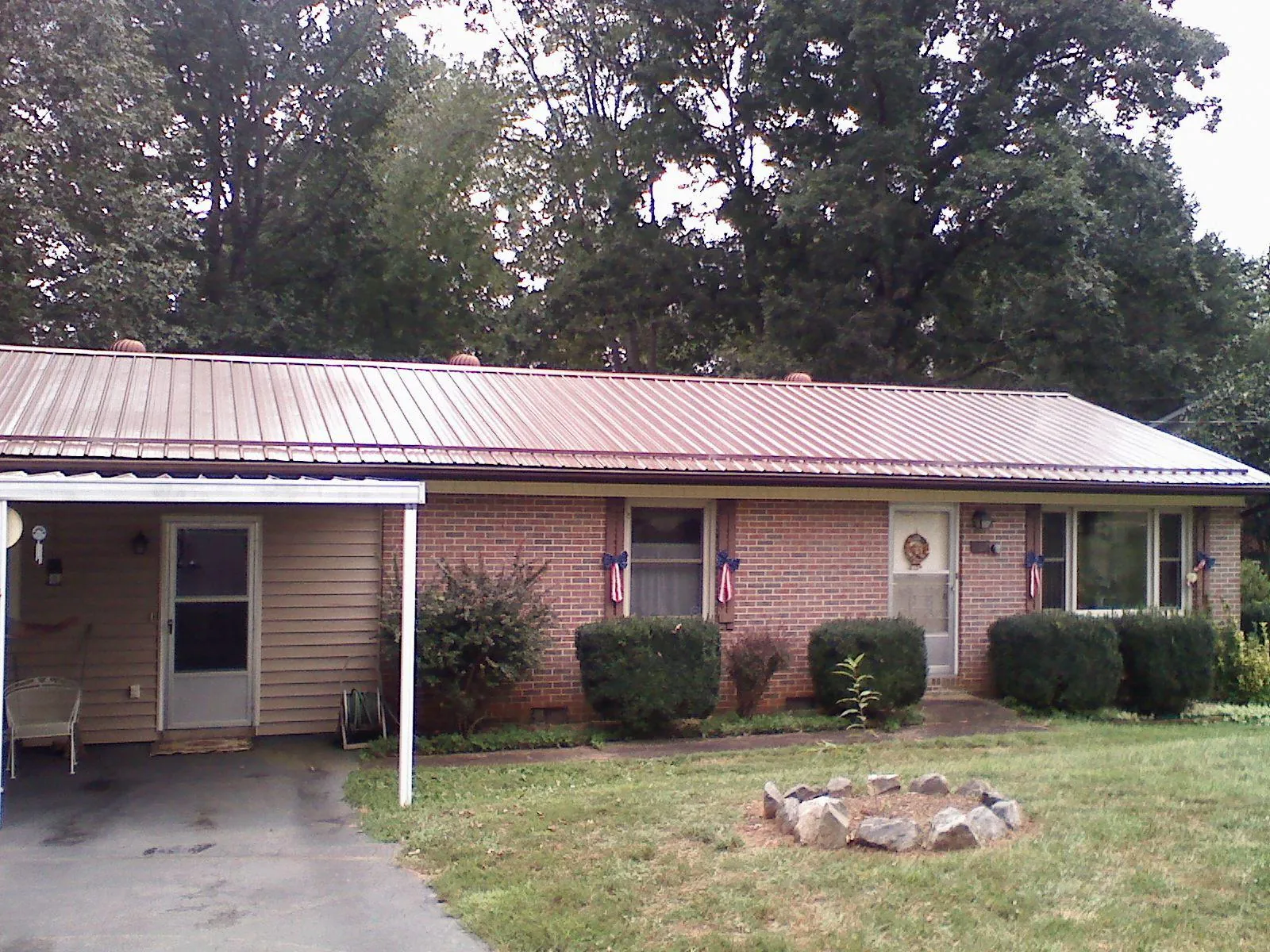 Bronze metal roof and carport on a brick ranch home — Roof Repair work by our crew in Midway